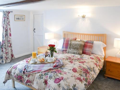 a bedroom with a bed with a tray of food on it at The Brambles in Horning