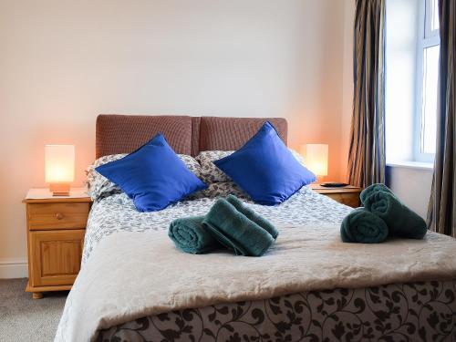 a bedroom with a bed with blue pillows at Seadrift in New Quay
