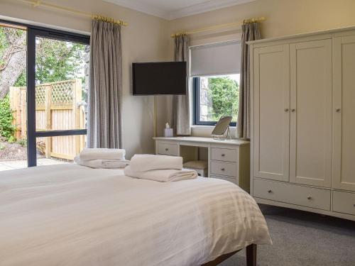een slaapkamer met 2 bedden, een bureau en een raam bij Church View - Ukc5700 in Castletown