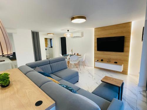 a living room with a blue couch and a table at Balans nad Jeziorem in Ślesin