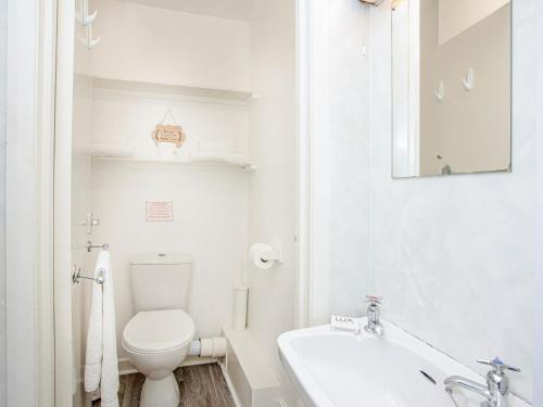 a white bathroom with a toilet and a sink at Apartment Ten - Uk39862 in Paignton