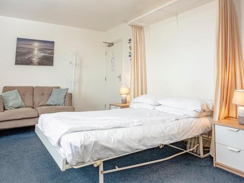 ein Schlafzimmer mit einem Bett und einem Sofa in der Unterkunft Apartment Ten - Uk39862 in Paignton