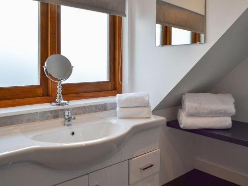 a bathroom with a sink and a mirror at Windmill Barn in Herstmonceux