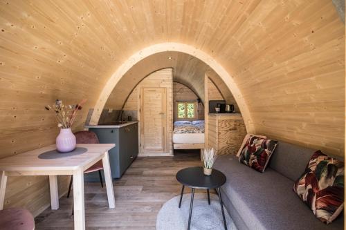 una habitación con sofá y mesa en una casa pequeña en Luxe woodlodge in een prachtige en bosrijke omgeving, en Bornerbroek