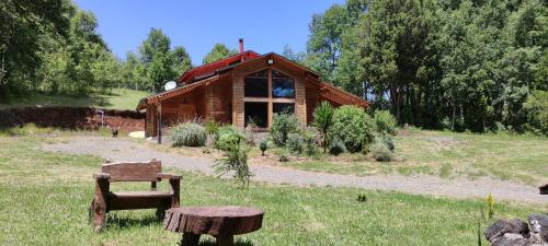 a log cabin with a bench in front of it at Mi Refugio del Sur in Licán Ray