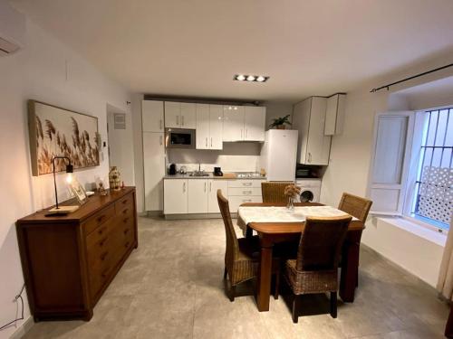 eine Küche mit einem Tisch und Stühlen sowie ein Esszimmer in der Unterkunft Moderno duplex en la Tacita de Plata in Cádiz