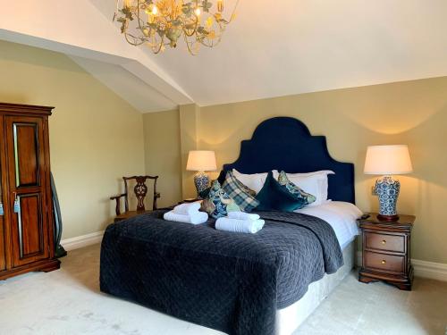 a bedroom with a large bed with a blue headboard at Tankardstown House in Slane