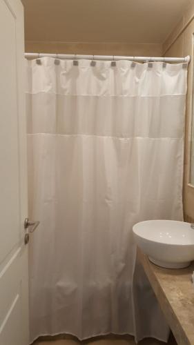 a bathroom with a white shower curtain and a sink at Departamento Caseros in Salta