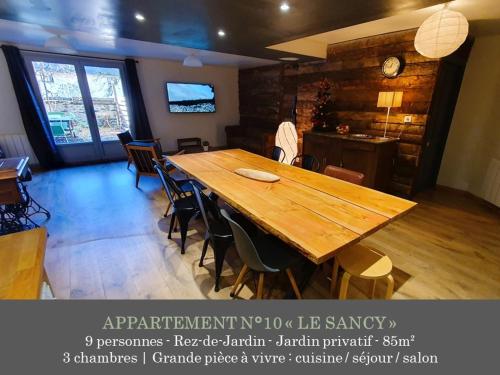 a large wooden table in a room with chairs at La Maison des Familles 10 appartements in Le Mont-Dore