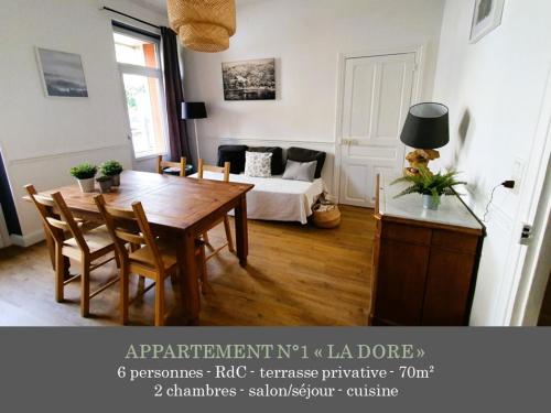 a living room with a table and a bed at La Maison des Familles 10 appartements in Le Mont-Dore