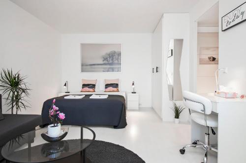 Cette chambre blanche comprend un lit et une table en verre. dans l'établissement Guest Apartment Tuuttikuja, à Kuopio
