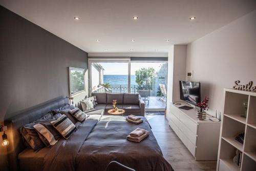 um quarto com uma cama grande e uma janela grande em Kalafatis beach home em Itea