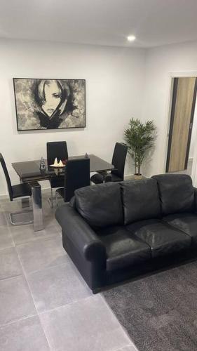 - un salon avec un canapé noir et une table dans l'établissement Confortable adosado en Elche, à Elche