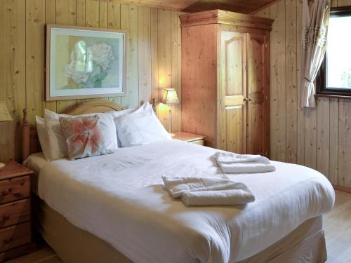 1 dormitorio con 1 cama con toallas en The Hive, en Warmwell