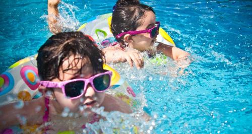 Dos niños en la piscina con gafas de sol en Tainá e Cezar's Park Caldas Novas, en Caldas Novas
