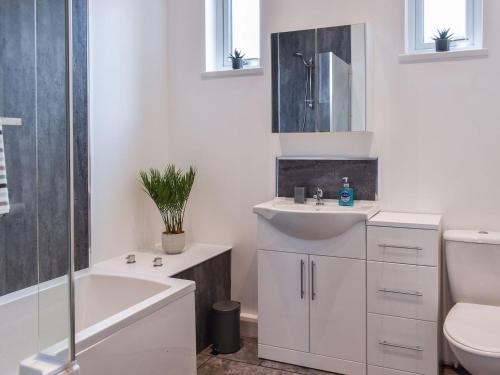 a white bathroom with a sink and a toilet at Seion Villa in Blaenau-Ffestiniog