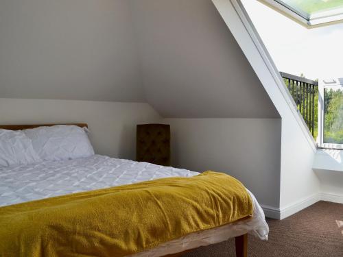 een slaapkamer met een bed met een gele deken bij Reeds Farmhouse in Bentley