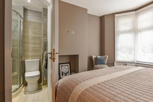 a bedroom with a bed and a shower and a toilet at Modern Two Bed with En-Suites and Private Parking in Cardiff