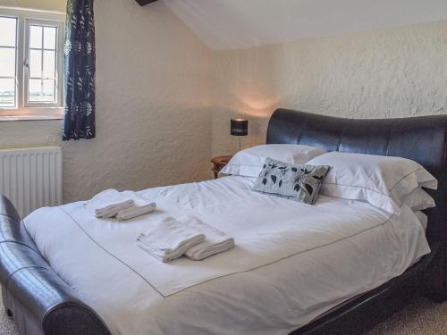 a large bed with white sheets and towels on it at Uk40277 - Llys Elen Two in Brynsiencyn