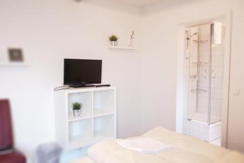 a white room with a television and a bed at Ellada Restaurant & Hotel in Tarp
