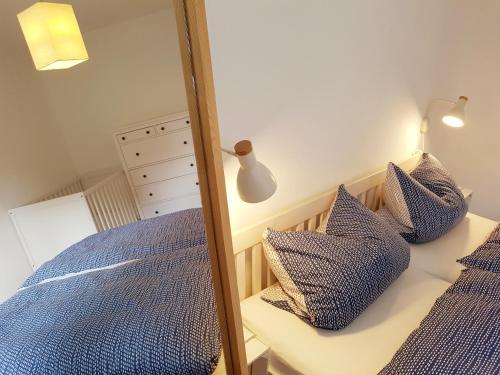 - une chambre avec un miroir à côté d'un lit dans l'établissement Ferienhaus an der Nordsee - familienfreundlich, gut ausgestattet & viel Platz, à Butjadingen