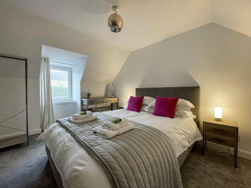 a bedroom with a large bed with towels on it at Willow Cottage in Sandwick