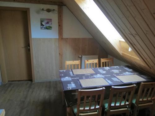 een eetkamer met een tafel en stoelen op een zolder bij Ferienwohnung - Landhotel Waldschlößchen in Sohland