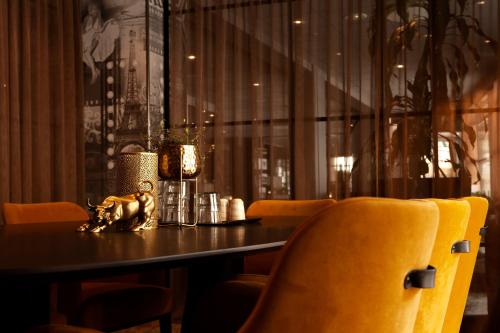 a dining room with a table and yellow chairs at Scandic Karlstad City in Karlstad