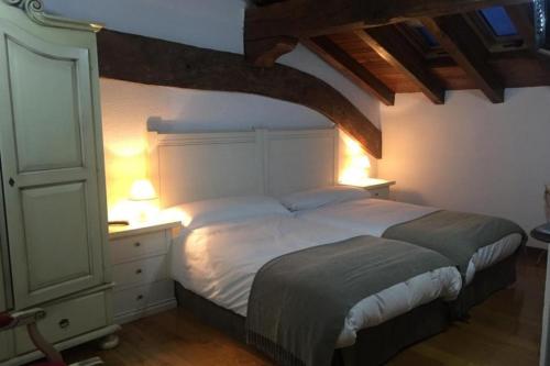 a bedroom with a bed and a dresser with two lamps at MAITETXU HABITACION in Viscarret-Guerendiáin