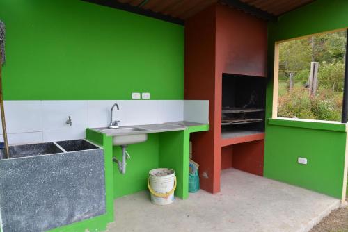 uma cozinha verde com um lavatório e uma janela em CABAÑAS SALEKA Paipa 