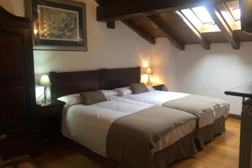 1 dormitorio con 1 cama grande, 2 mesitas de noche y 2 lámparas en MAITETXU HABITACION, en Viscarret-Guerendiáin