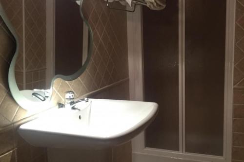 La salle de bains est pourvue d'un lavabo blanc et d'un miroir. dans l'établissement MAITETXU HABITACION, à Viscarret-Guerendiáin