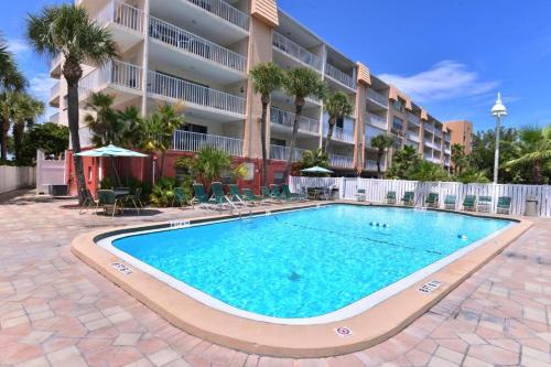 una piscina frente a un edificio de apartamentos en Beach Oasis - Beautifully Remodeled Beachside Condo at Holiday Villas II with Heated Pool! en Clearwater Beach