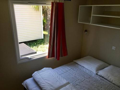 a small bedroom with a bed and a window at De Pujol Greenchalets Argeles sur Mer in Argelès-sur-Mer