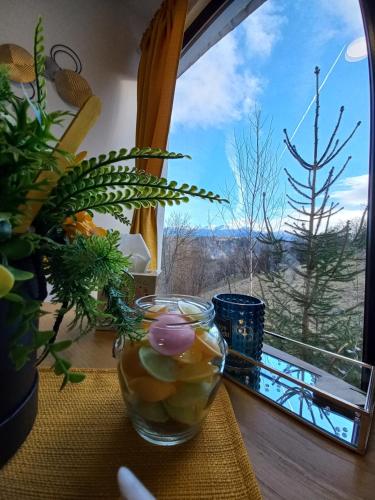 a glass bowl of fruit on a table in front of a window at Touch the Sky in Moieciu de Jos