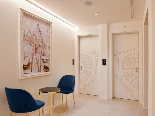 a room with two doors with blue chairs and a table at Relais Forte Benedek Wine & SPA - Adults Only in Pastrengo