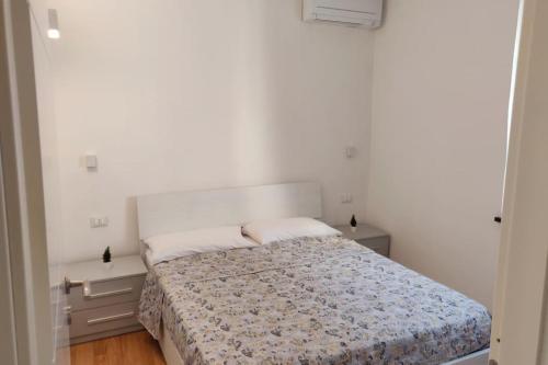 um quarto branco com uma cama e duas mesas de cabeceira em La Casa di Dani em Génova