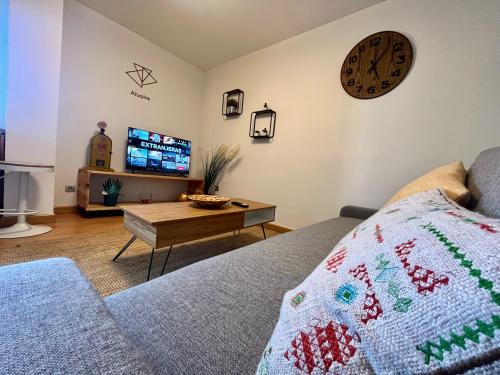 a living room with a couch and a clock on the wall at Cardenal Segura - Rozando la Catedral- Centro Historico in Burgos