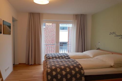 エッカーンフェルデにあるDIE kleine FEINEのベッドルーム1室(ベッド1台、大きな窓付)