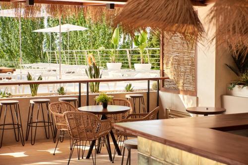 un restaurante con mesas y sillas y un bar en DWO Sirius - Adults Only, en Santa Susanna