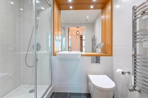 a bathroom with a shower and a toilet and a sink at CannySuite 1BED in London