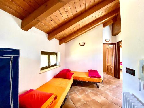 Cette chambre comprend 2 lits avec des oreillers rouges. dans l'établissement Villa di Charme, à Gignod