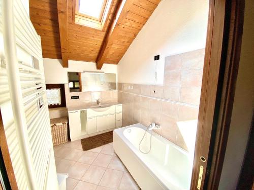 y baño con bañera y lavamanos. en Villa di Charme, en Gignod