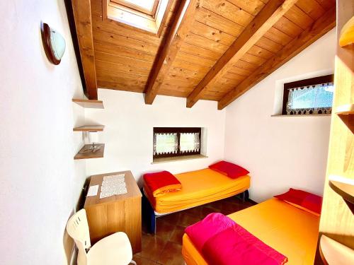 a small room with two beds and a desk at Villa di Charme in Gignod
