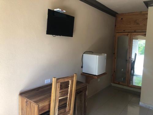 um quarto com uma televisão na parede e um frigorífico em Hotel Cambri em Nagua