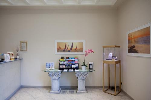 a table in a room with paintings on the wall at Albergo Belsoggiorno in Sanremo