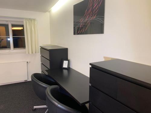 an office with a black desk and two chairs at Penzion a Restaurace 14 in Hostinné