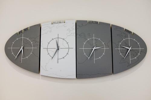 a group of three clocks on a wall at Albergo Belsoggiorno in Sanremo