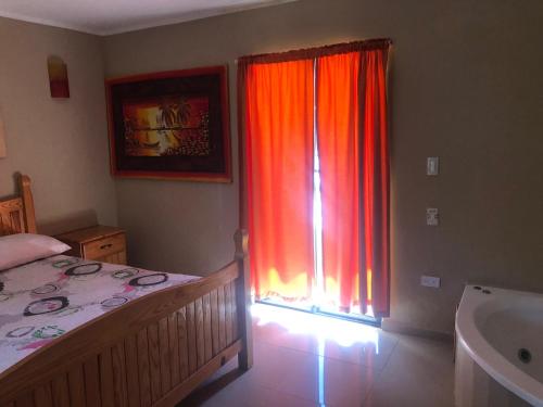 a bedroom with a bed and a window with curtains at Hotel Cambri in Nagua