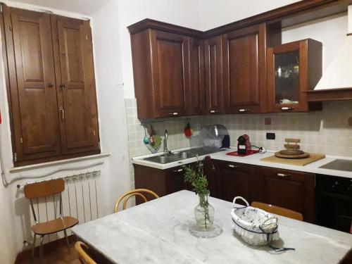 a kitchen with wooden cabinets and a table with a vase on it at gite Da Clara in Serrazzano
